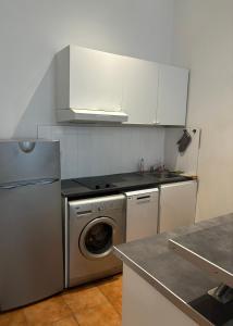 a kitchen with a washing machine and a refrigerator at T2 vue mer CATALANS - NETFLIX - VELODROME in Marseille