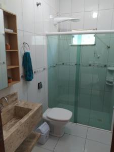 a bathroom with a glass shower and a toilet at Imóvel com 02 quartos próxima ao Morro do Macaco in Bombinhas