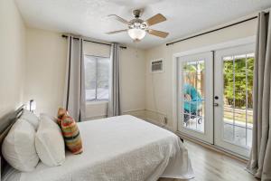sypialnia z łóżkiem i wentylatorem sufitowym w obiekcie Beach Bungalow By The Sea 4 w mieście Cocoa Beach