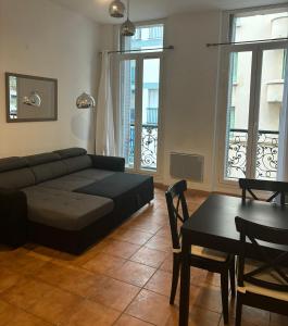 ein Wohnzimmer mit einem Sofa und einem Tisch in der Unterkunft T2 vue mer CATALANS - NETFLIX - VELODROME in Marseille