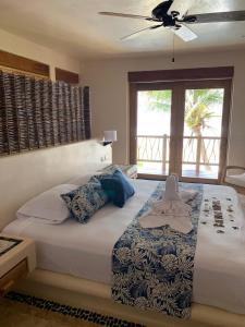 a bedroom with a large bed with a ceiling fan at New Beachfront Villa in Playa Blanca in Zihuatanejo