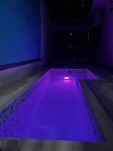 - une piscine avec des lumières violettes dans une chambre dans l'établissement Apt 2 Hab con Piscina Privada! Cerca a Playa, à San Antero