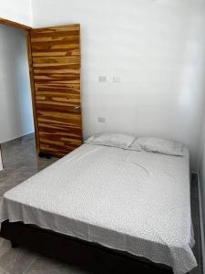 - une chambre avec un lit et une commode en bois dans l'établissement Apt 2 Hab con Piscina Privada! Cerca a Playa, à San Antero