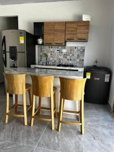 uma cozinha com uma mesa e cadeiras e um frigorífico em Apt 2 Hab con Piscina Privada! Cerca a Playa em San Antero