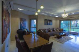 sala de estar con sofá y mesa en Prestigia golf city porte agate, en Marrakech