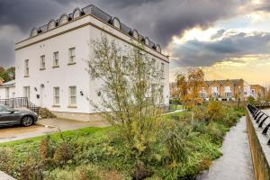 Un edificio blanco con un coche aparcado delante. en Modern 2BR 2BA with Free Parking - Sleeps 6, en Hemel Hempstead