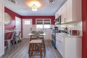 - une cuisine avec des placards blancs et des murs rouges dans l'établissement Rear deck w/ Soaking tub + Wi-Fi & Parking, à Graham
