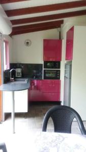 een keuken met rode kasten en een wastafel bij Ti Coco in Trois-Rivières