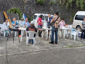 a group of people sitting at tables in a parking lot at 椿リゾートみさき in Shirahama
