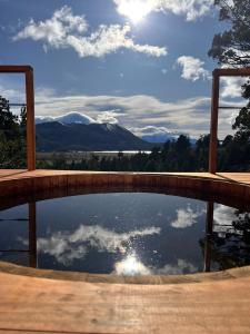 una piscina de agua con vistas a las montañas en Casa Terraplen con tina privada y vista a la laguna en Trevelín