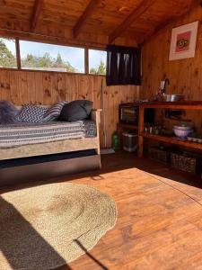 ein Schlafzimmer mit einem Bett in einer Holzhütte in der Unterkunft Casa Terraplen con tina privada y vista a la laguna in Trevelín