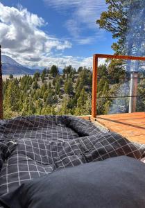 Bett auf einer Terrasse mit Bergblick in der Unterkunft Casa Terraplen con tina privada y vista a la laguna in Trevelín