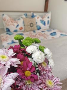 a vase filled with flowers sitting on a bed at Fewo Wolgast Usedom Ostsee in Wolgast