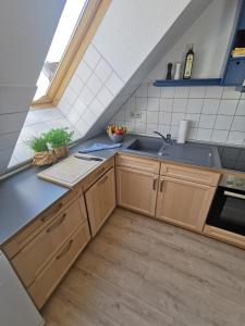 a kitchen with wooden cabinets and a sink at Fewo Wolgast Usedom Ostsee in Wolgast +5 photos