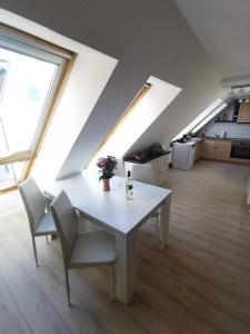 a white table and chairs in a room with windows at Fewo Wolgast Usedom Ostsee in Wolgast