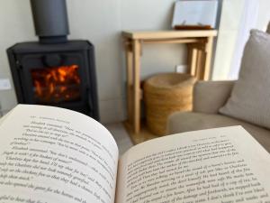an open book sitting on a table with a fireplace at Compass Hut in Melrose