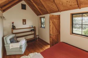 Zimmer mit einem Bett, einem Stuhl und einem Fenster in der Unterkunft The River Retreat Off The Grid in Inglewood