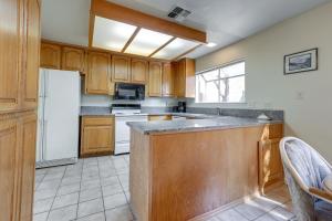 a kitchen with wooden cabinets and a white refrigerator at Pet-Friendly Citrus Heights Home Fenced Backyard! in Citrus Heights