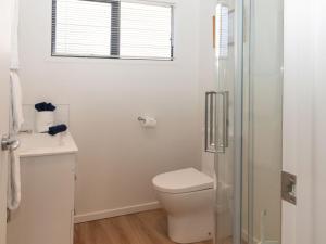 a white bathroom with a toilet and a shower at The Ocean Outlook Pure Luxury in New Plymouth