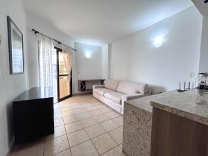 ein Wohnzimmer mit einem Sofa und einem Tisch in der Unterkunft Apartamento no Mercure - canal 3 in Santos