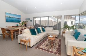 a living room with a white couch and a table at The Ocean Outlook Pure Luxury in New Plymouth