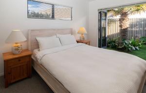 a bedroom with a large white bed and a window at The Ocean Outlook Pure Luxury in New Plymouth