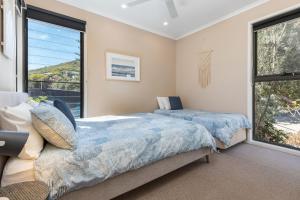a bedroom with two beds and a large window at Boom 1 in Blueys Beach +20 photos