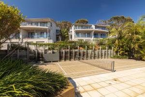 a tennis court in front of a building at Boom 1 in Blueys Beach