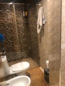 een badkamer met een toilet en een glazen douche bij Villa près de l’aéroport casa in Deroua