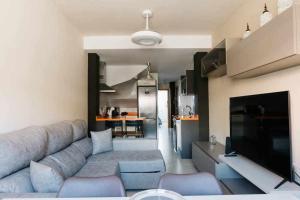 a living room with a couch and a kitchen at Frente a Puerto Azahar 3 in Grao de Castellón