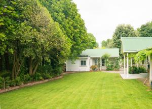 una casa con un gran patio delante de ella en Birdsong Cottage, en Paraparaumu