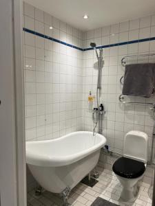 ein weißes Bad mit einer Badewanne und einem WC in der Unterkunft Apartment in the middle of So-Fo, Södermalm, 67sqm in Stockholm