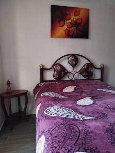 1 dormitorio con cama morada y edredón morado en Departamento Independiente completo, Centro Histórico Quito en Quito
