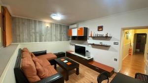 The Victoria Apartament in Hellín في إيّين: غرفة معيشة مع أريكة وتلفزيون