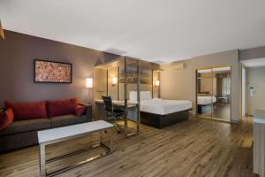 Best Western Diamond Bar Hotel & Suites في دياموند بار: غرفة معيشة مع أريكة وغرفة نوم