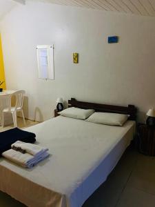 a bedroom with a large white bed with towels on it at SOL in Búzios