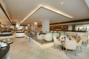 un restaurante con bar, mesas y sillas en Hilton Xi'an High-tech Zone en Xi'an