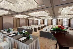 um salão de banquetes com mesas, cadeiras e lustres em Hilton Xi'an High-tech Zone em Xi'an