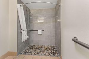 La salle de bains est pourvue d'une douche avec une porte en verre. dans l'établissement Quality Inn Sandersville, à Sandersville