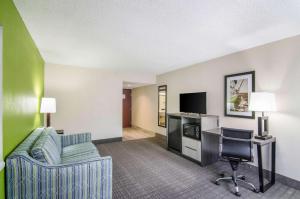 a hotel room with a couch and a desk and a tv at Quality Inn Saraland in Saraland