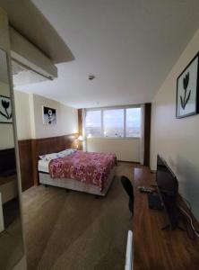 a bedroom with a bed and a desk and a computer at 512. Flat hotel Go Inn in Brasilia