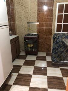 a kitchen with a stove and a checkered floor at NUB Guest House in Aswan +22 photos