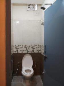 a small bathroom with a toilet in a stall at The Nisarga Residency in Bangalore