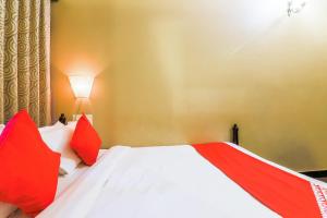 a bedroom with a bed with red pillows at Kams Coco De Parra in Baga