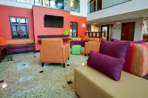 a lobby with couches and a flat screen tv at Drury Inn & Suites Terre Haute in Terre Haute