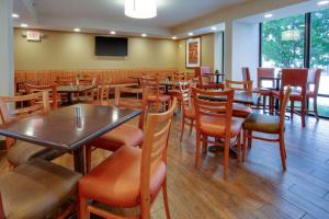 a restaurant with tables and chairs and a television at Drury Inn & Suites Terre Haute in Terre Haute