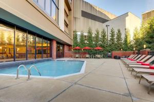 a swimming pool in front of a building with tables and chairs at Drury Plaza Hotel Columbus Downtown in Columbus