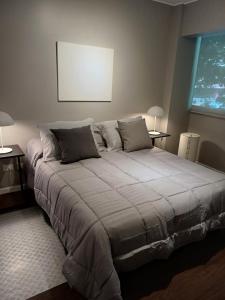 1 cama grande en un dormitorio con 2 mesas en Estudio VIP en Recoleta en Buenos Aires