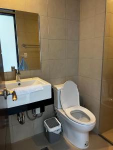 a bathroom with a toilet and a sink and a mirror at 1 Bedroom Condo unit across Iloilo Convention Center in Iloilo City