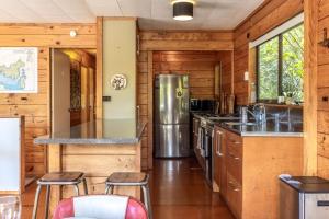 a kitchen with wooden walls and a refrigerator at Onetangi Bliss - Waiheke Island Holiday Home in Onetangi